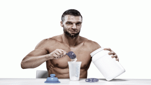 Homem forte, sem camisa, preparando whey protein