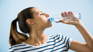 mulher tomando uma garrafa de agua