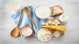 leite, queijo branco, queijo amarelos, iogurte, em recipiente separados em cima da mesa