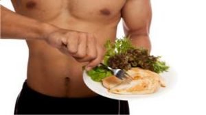 Corpo masculino sem camisa com um prato de comida com salada e frango grelhado.