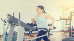 Mulher correndo em cima de uma esteira, treino para emagrecer