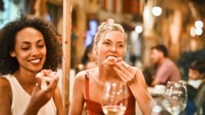 mulheres comendo pizza erros na hora de mudar a composição corporal
